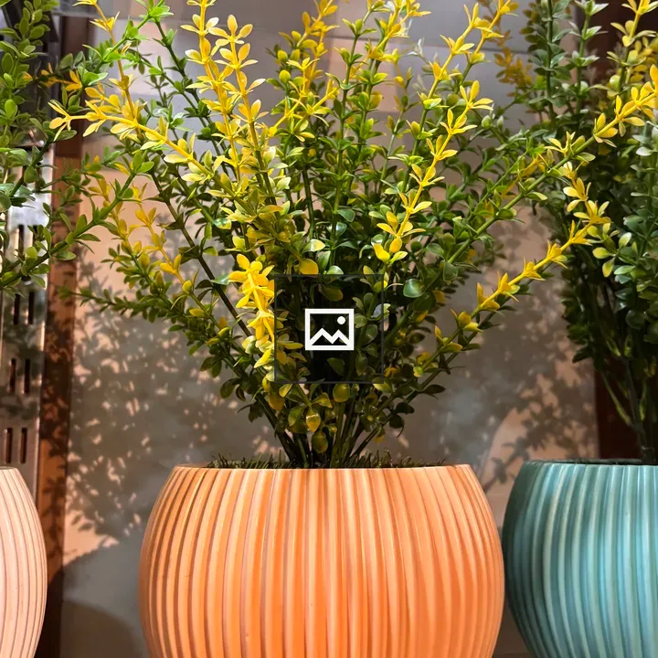 Vibrant artificial plant in orange vase