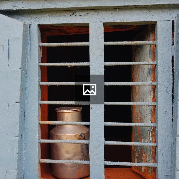 Metal Milk Can Behind Window Bars