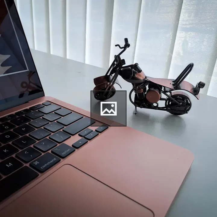 Laptop and miniature motorbike on desk