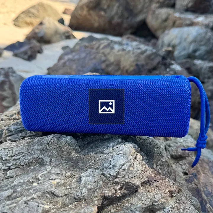 Blue portable speaker on rock