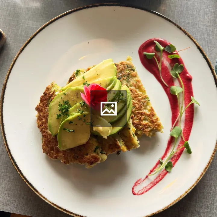 Savory corn fritter with avocado and flowers