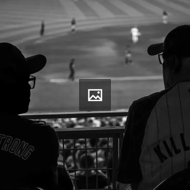Two men talking at baseball game