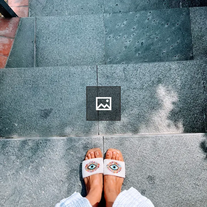 Feet on gray stone steps with sandals