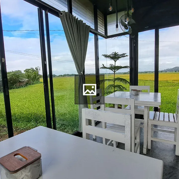 White tables and chairs by rice paddy