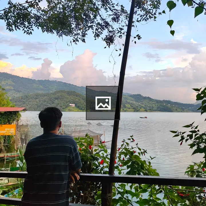 Person by railing overlooking lake