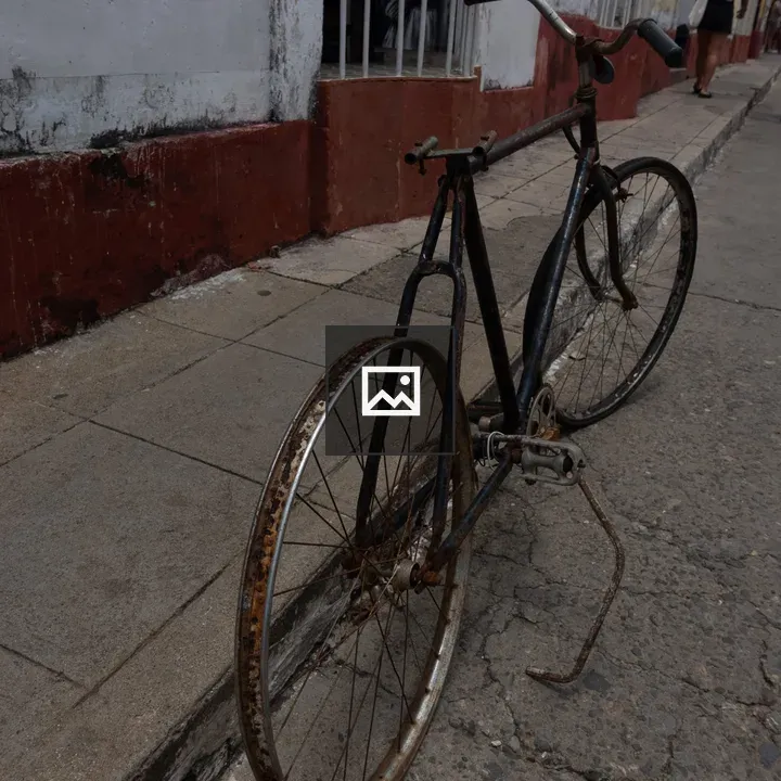 Rusty bicycle on cracked sidewalk