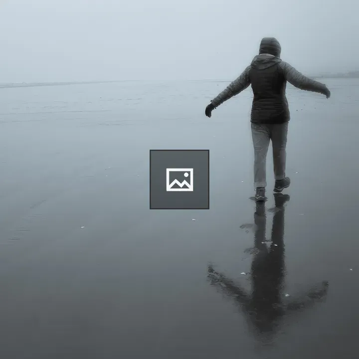 Person Walking on Rainy Beach