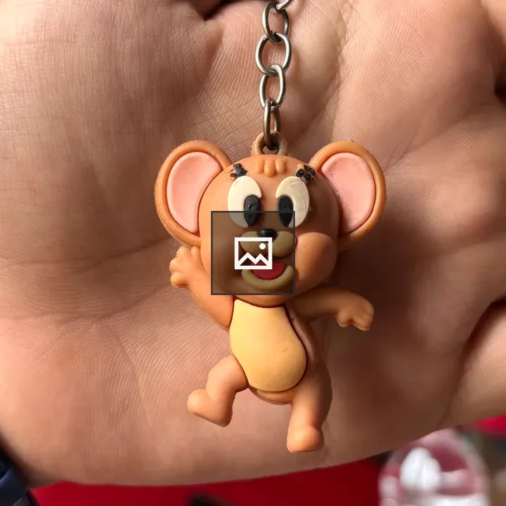 Close-up of hand with cartoon mouse keychain