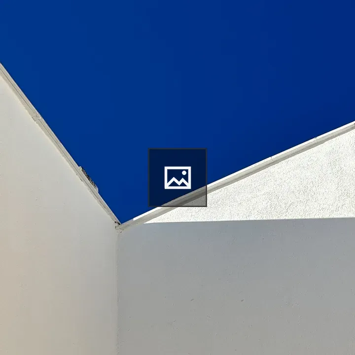 Corner of white wall and blue sky