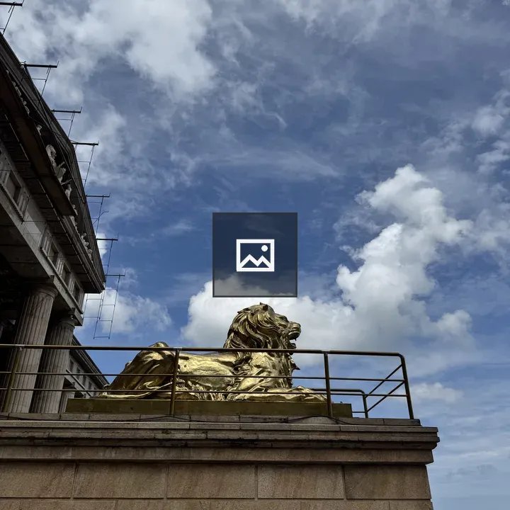 Golden lion statue on stone platform