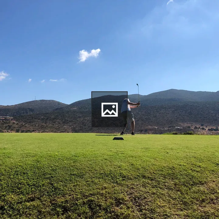 Golfer Swinging Under Blue Sky