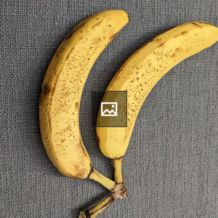Two older bananas on gray cloth