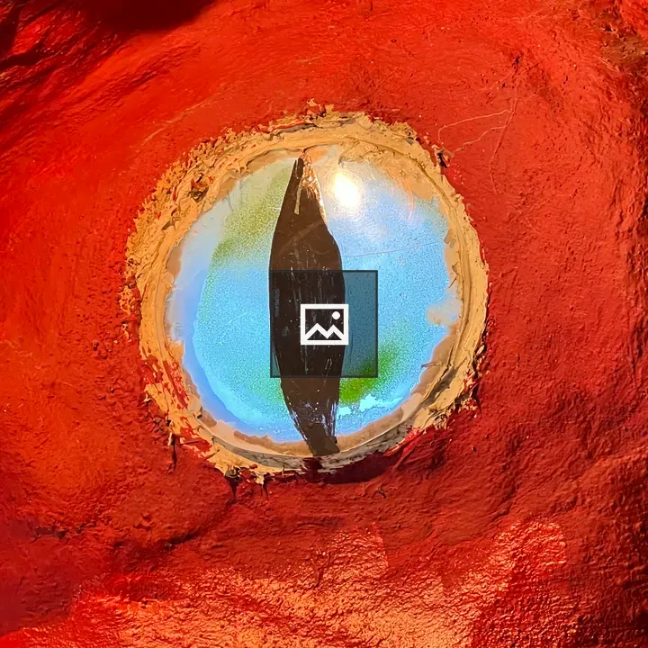 Painted Blue Eye on Red Wall