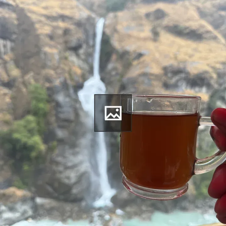 Person with tea mug and waterfall