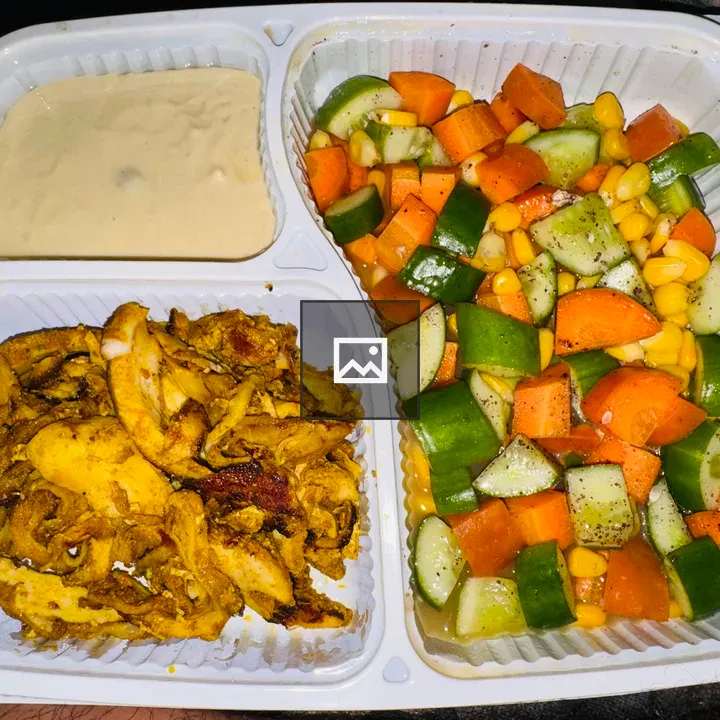 White takeout box with chicken and salad