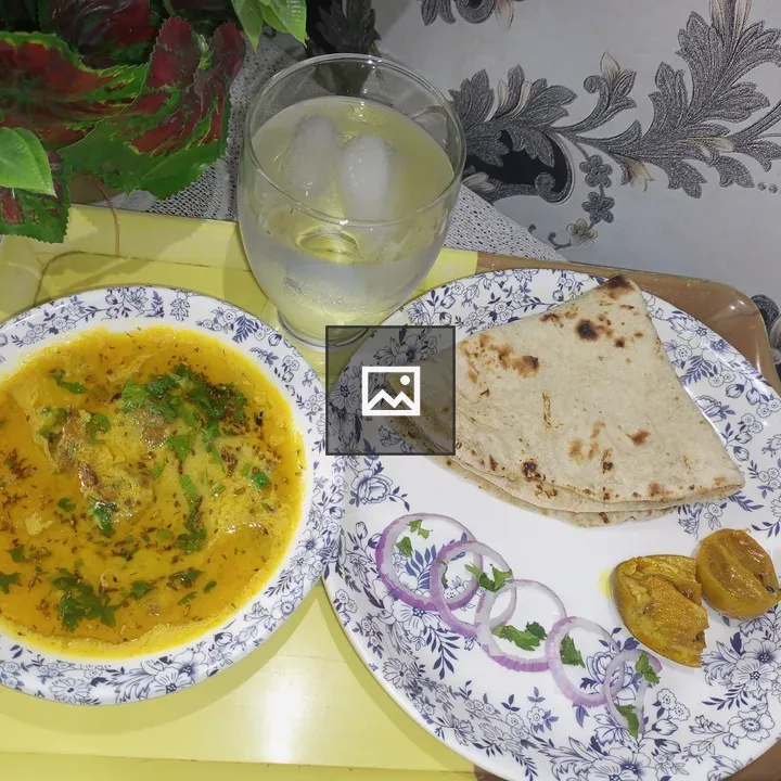 Dal with chapati and pickle on tray