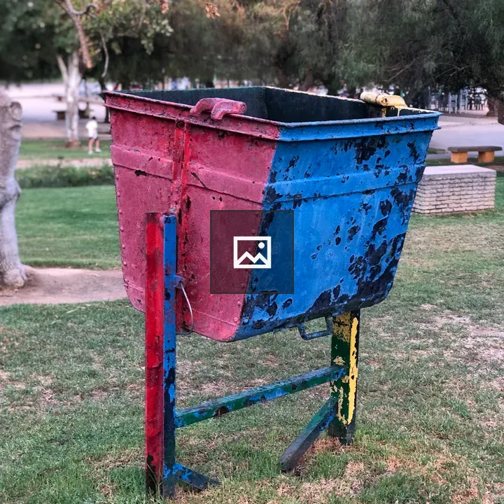 Worn red-and-blue trash container