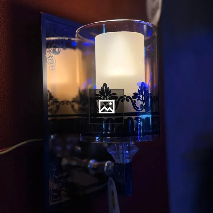 Decorative wall sconce with frosted glass candle holder