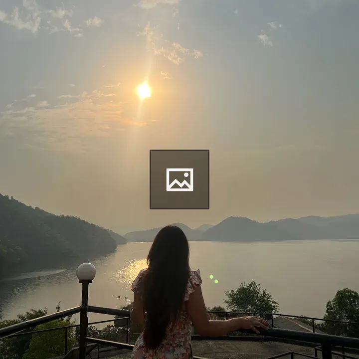 Girl on Balcony Looking at Sunset Over Lake
