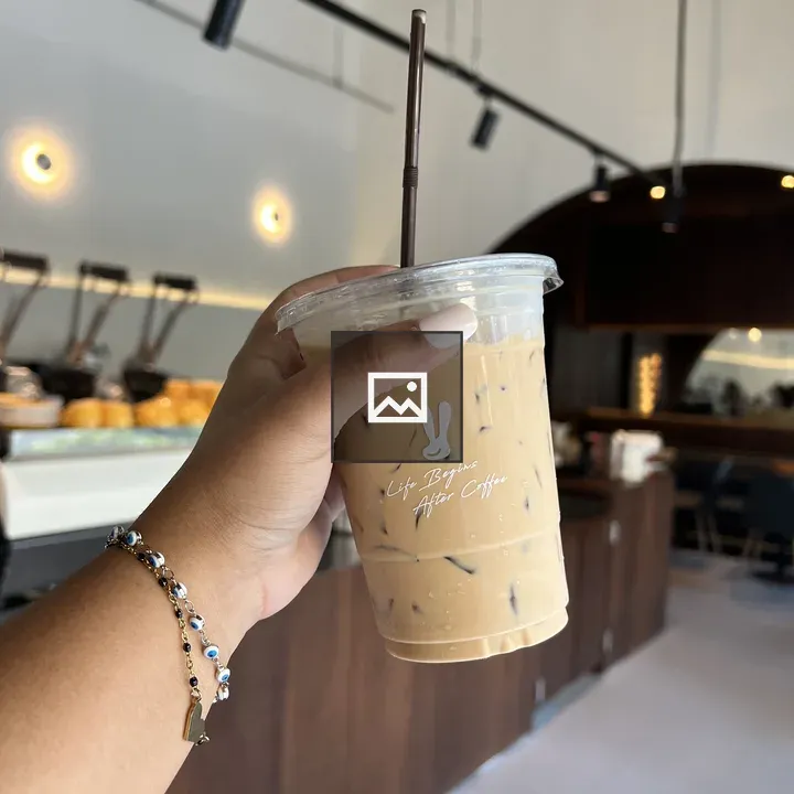 Cup of iced coffee with hand