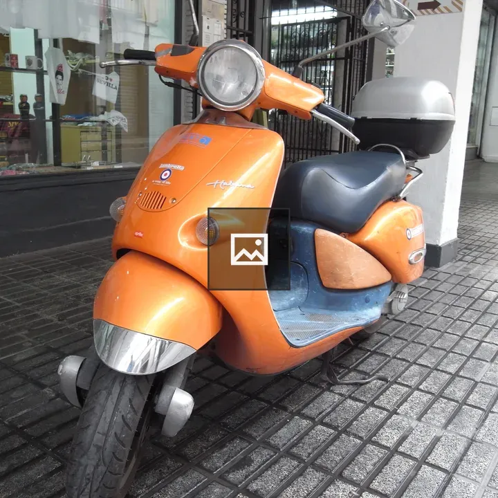 Orange scooter on sidewalk