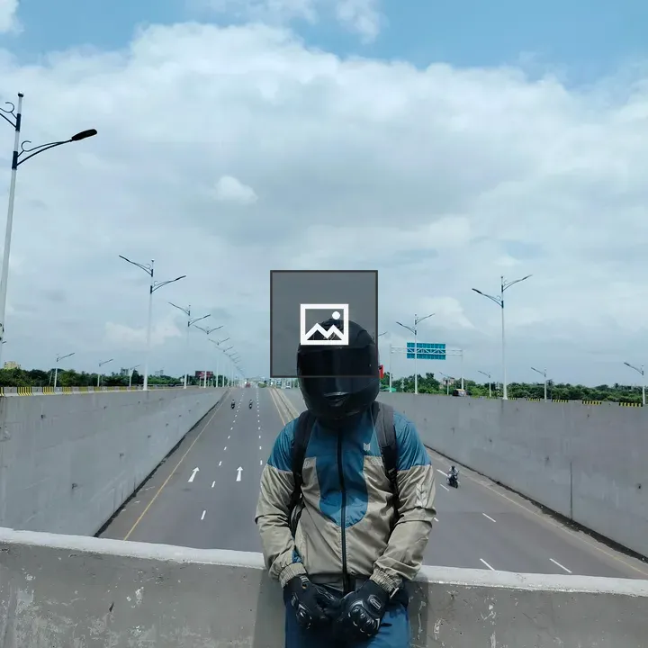 Person in Motorcycle Gear on Barrier