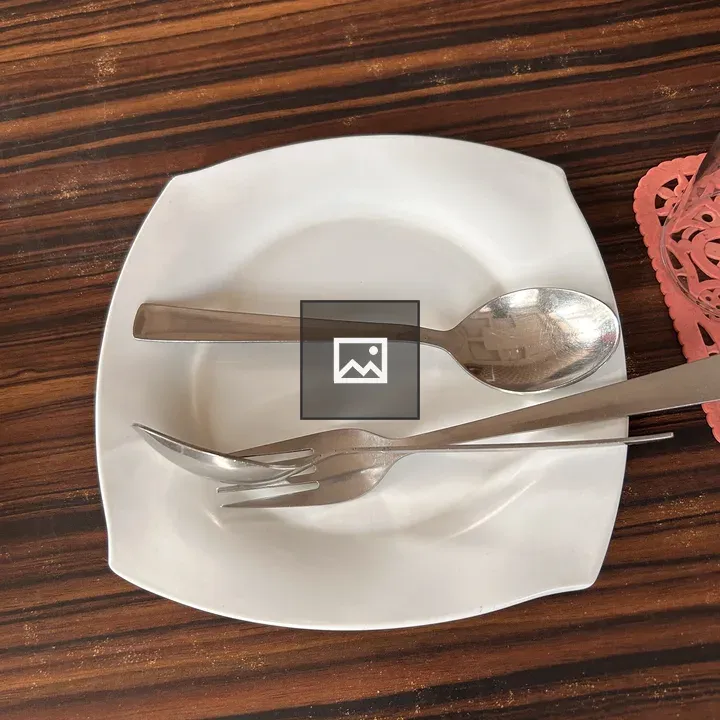 White plate with cutlery on wood
