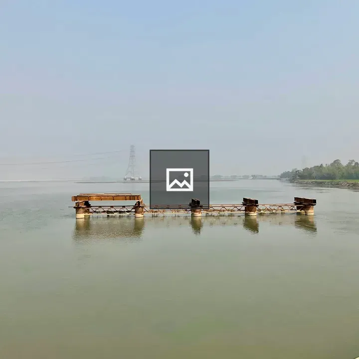Calm river with weathered bridge