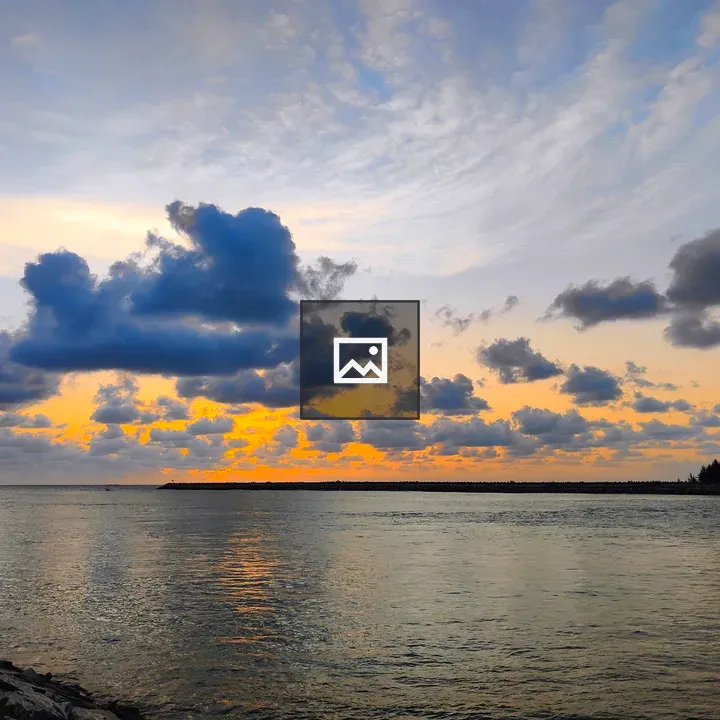 Sunset over water with jetty and trees