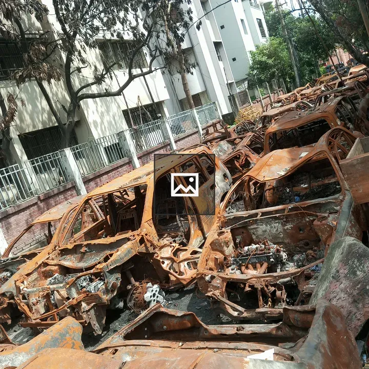 Rusty car wrecks beside modern building