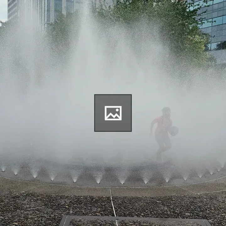 Child Running Through Water Fountain