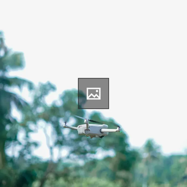 Drone in Flight Over Green Landscape