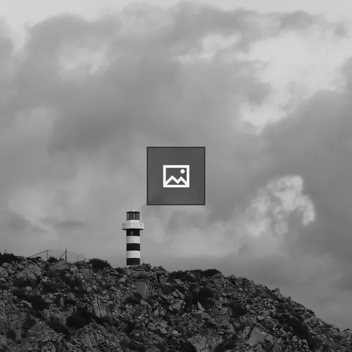 Striped lighthouse on rocky hill