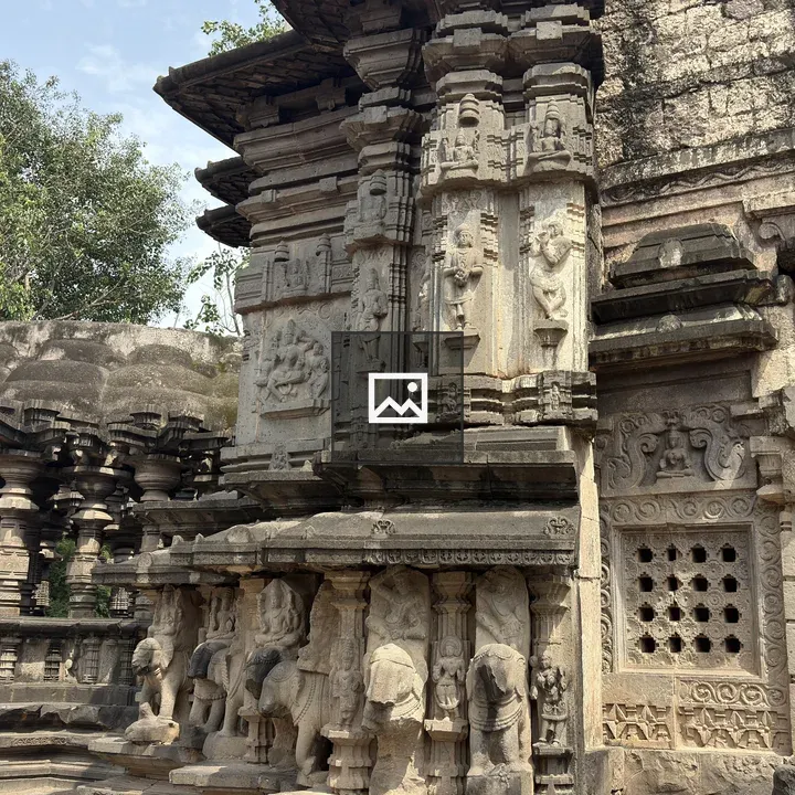 Side view of carved temple with deity symbols