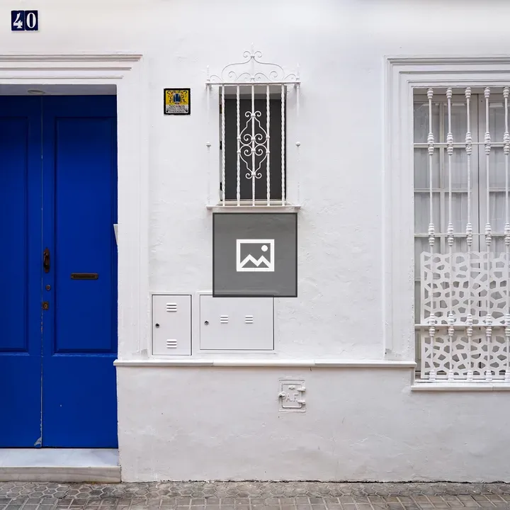 Very white house with blue door