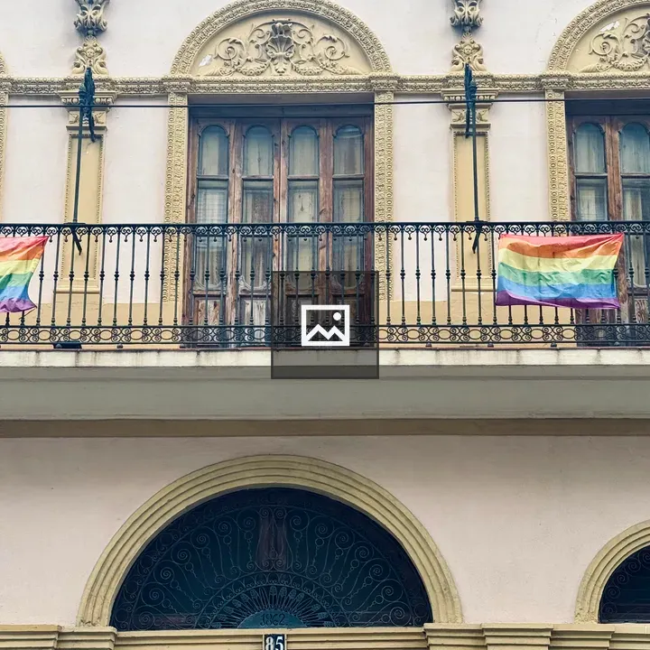 Two pride flags on balcony railing