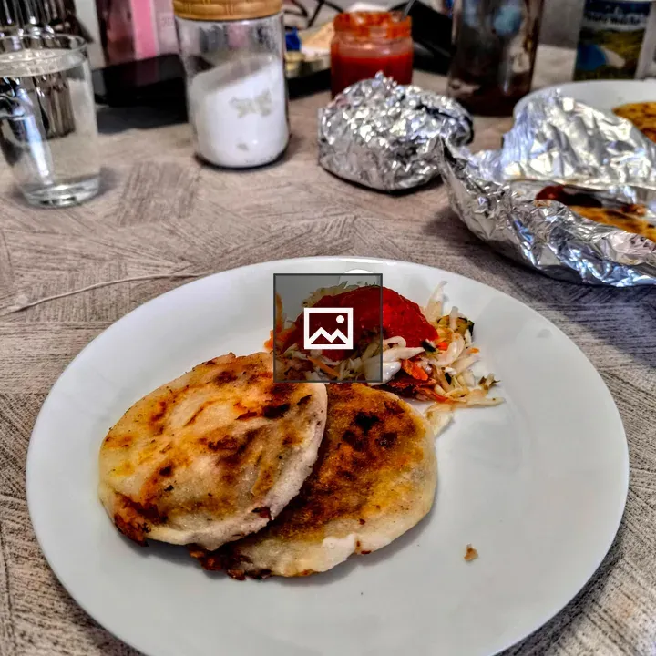 Two golden pupusas on plate