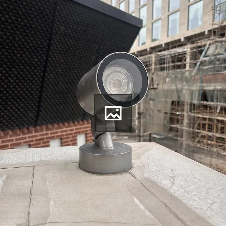 Security camera on ledge with building in background