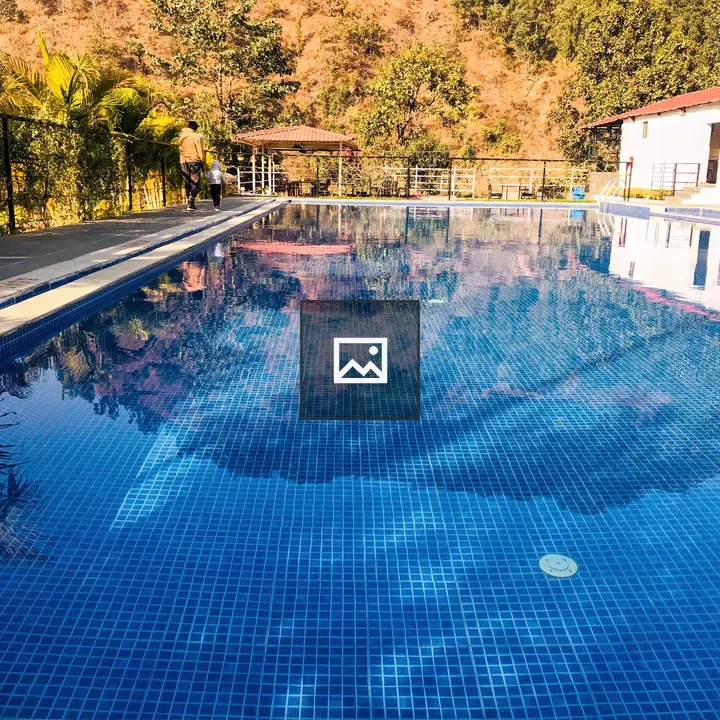 Blue-tiled pool by white building