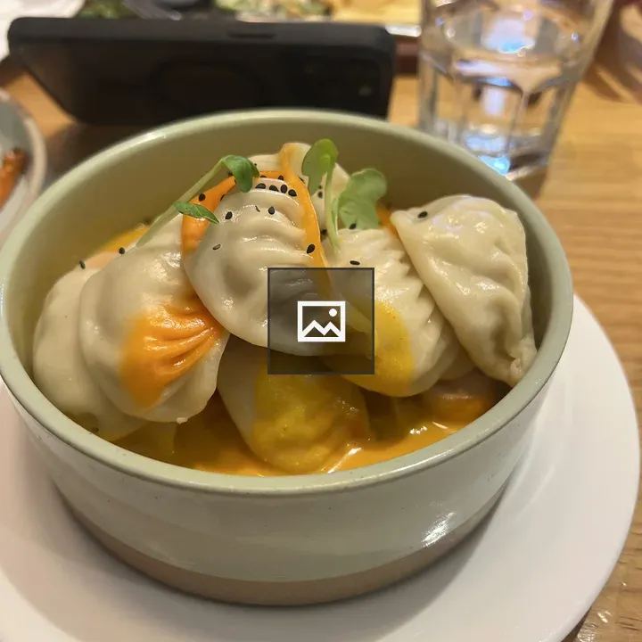 Bowl of dumplings in orange sauce