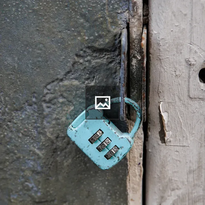 Turquoise padlock on weathered door