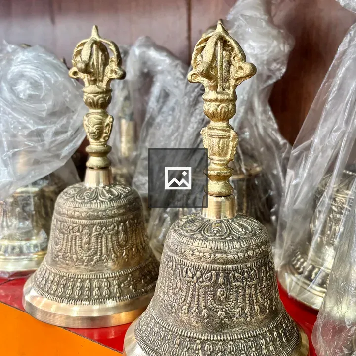 Brass bells on wooden shelf