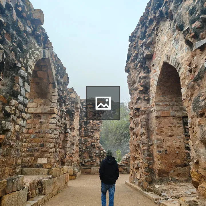 Person in hoodie on ruins path