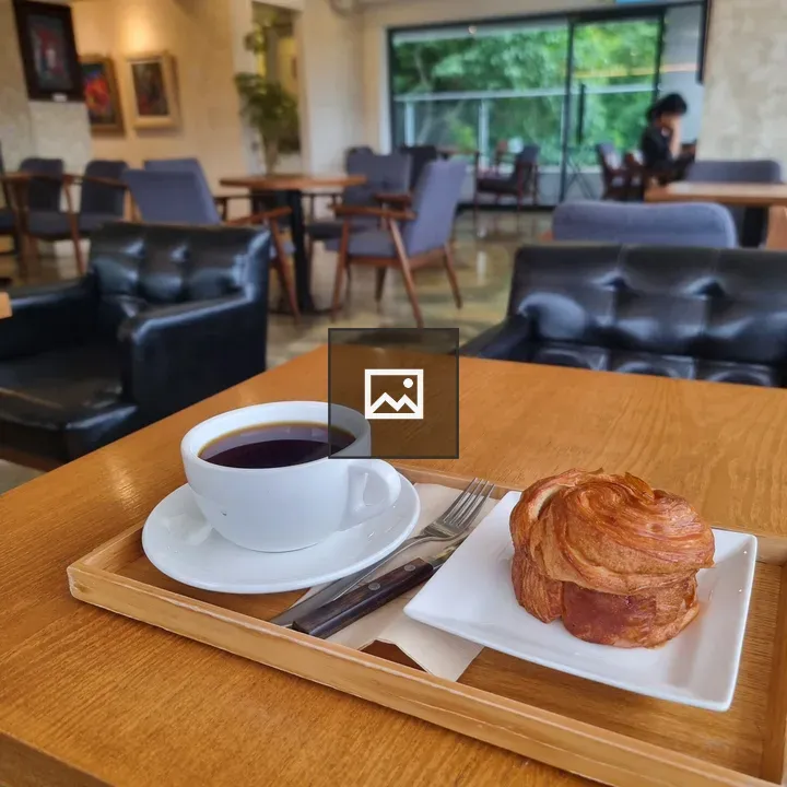 Cup of coffee and croissant on tray