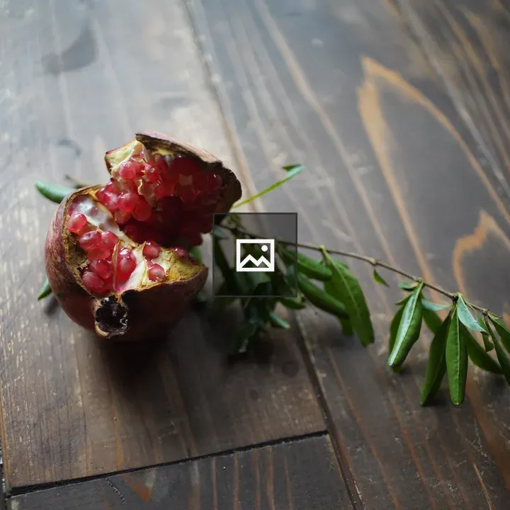 Pomegranate with Seeds on Wood