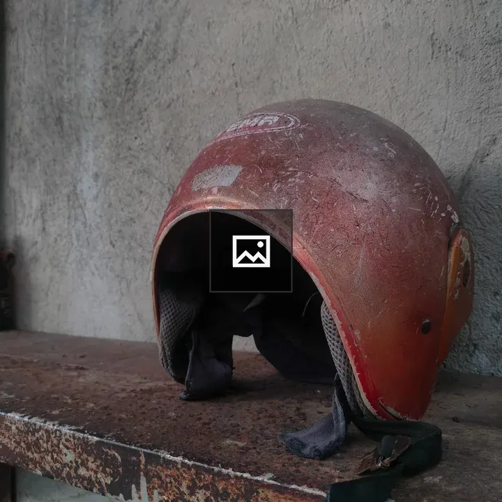 Old helmet beside beer bottle