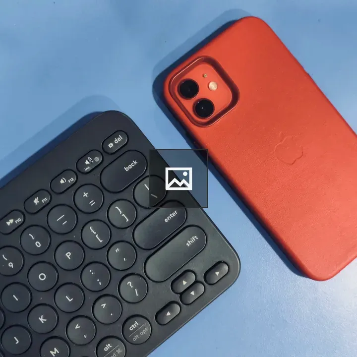 Partial view of black keyboard and red iPhone