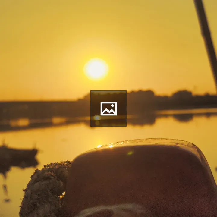 Sunset Over Water with Boats and Bridge