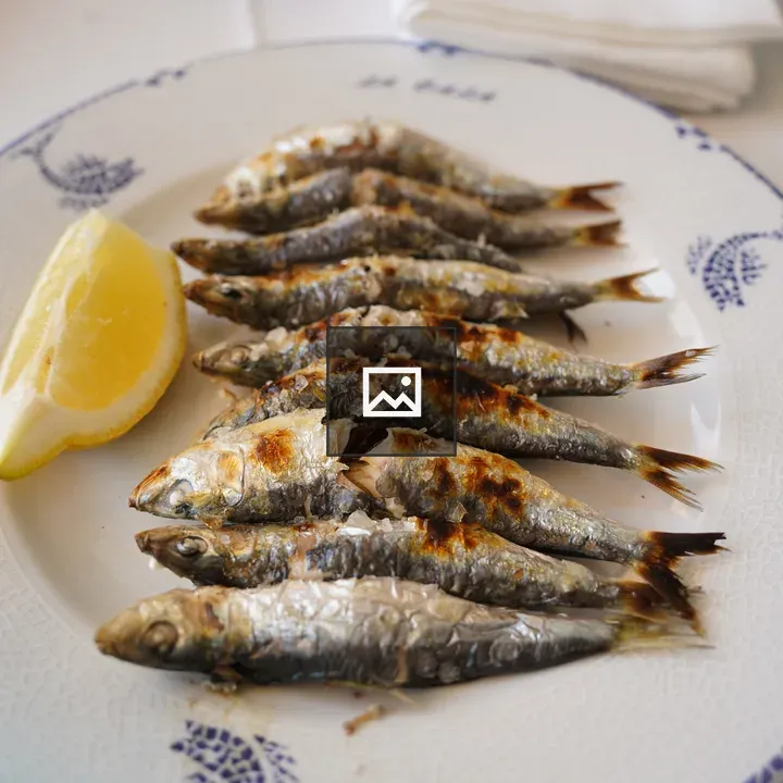 Plate of grilled sardines with lemon