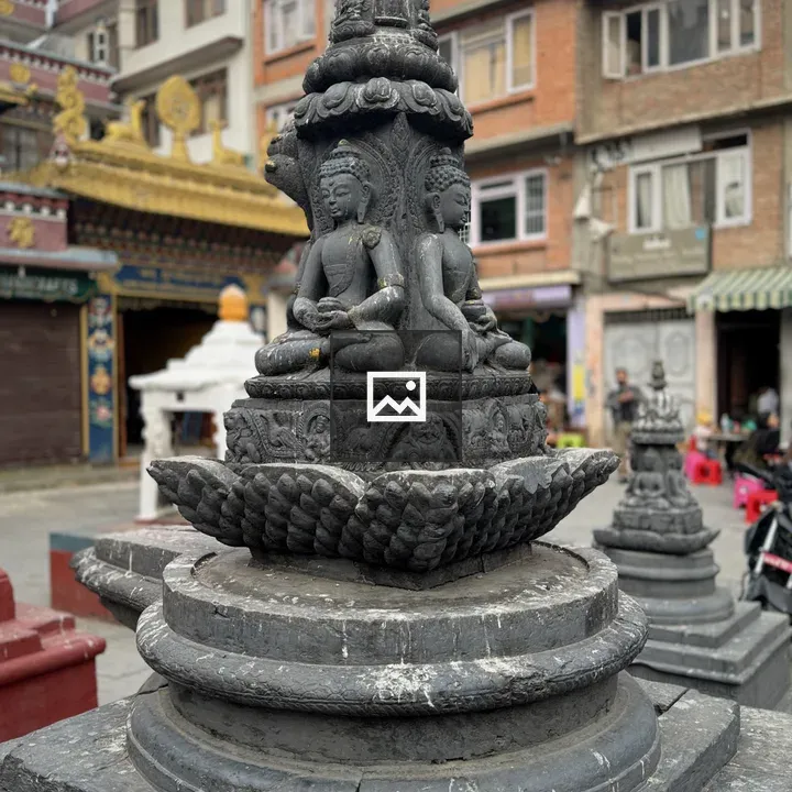Dark stone statue with meditative figures